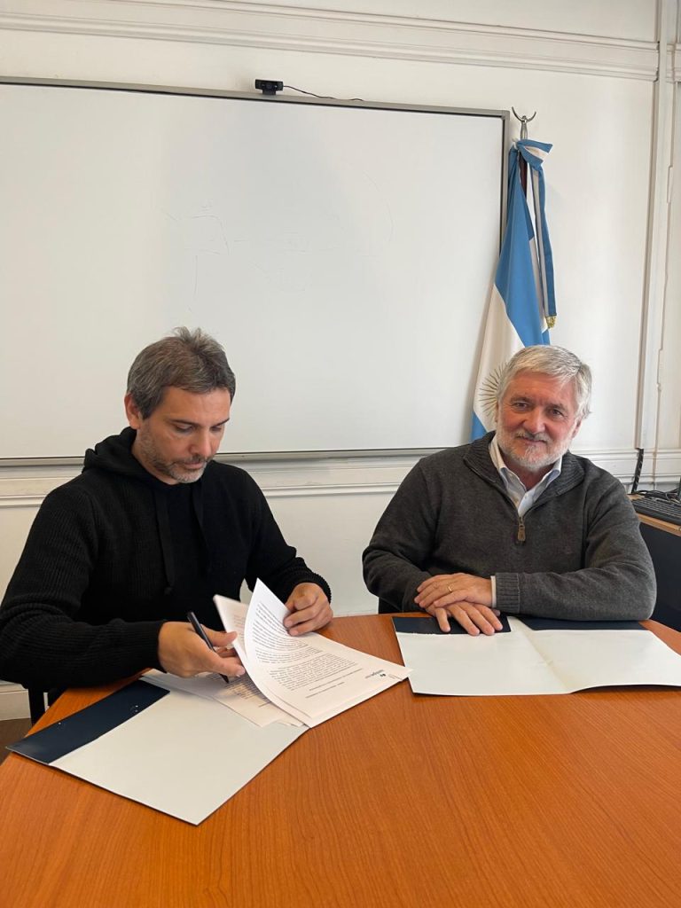 Rappresentanti di Fundación Argentina ASE e UNIPE durante la firma di un accordo istituzionale a un tavolo di lavoro.
